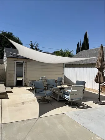 a backyard of a house with fire pit and outdoor seating