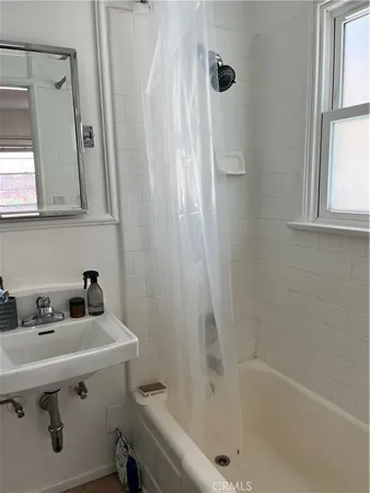 a bathroom with a sink a mirror and a bathtub