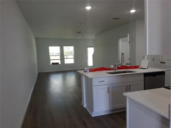 a room with kitchen island stainless steel appliances a stove refrigerator a sink and a counter top space