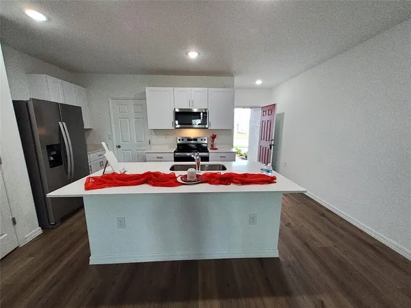 a kitchen with a sink a stove top oven a refrigerator and cabinets