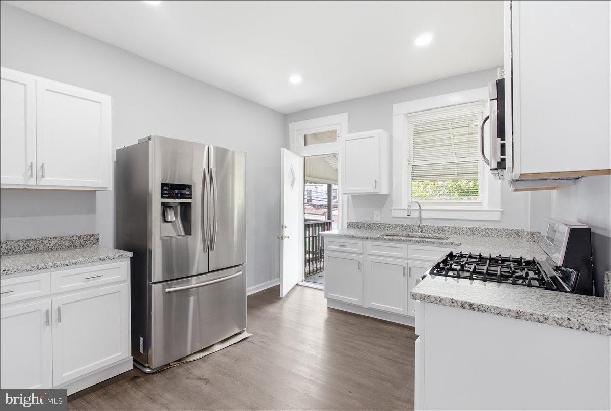 1231 North Potomac Street Baltimore, MD 21213 - Photo 8 of 25 a kitchen with granite countertop a refrigerator stove top oven and sink