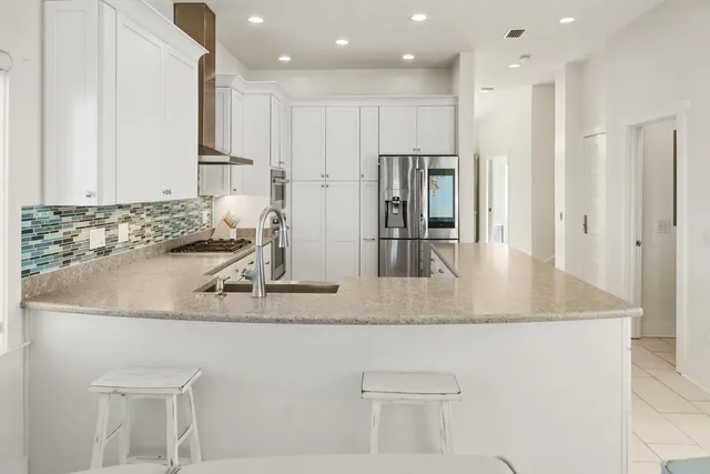 a kitchen with stainless steel appliances granite countertop a sink and a refrigerator