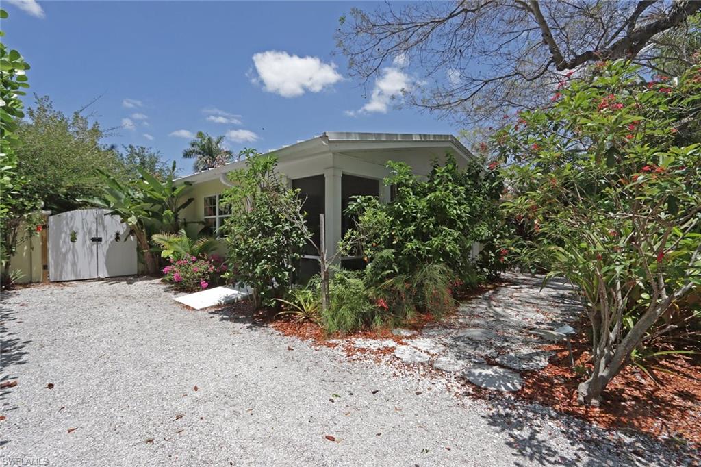361 1st Avenue North Naples, FL 34102 - Photo 2 of 31 a front view of a house with a yard and a garage