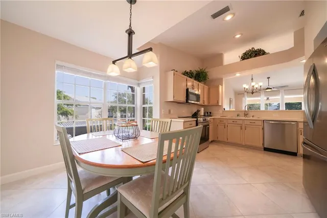 a view of a dining room and livingroom with furniture a rug a kitchen and view