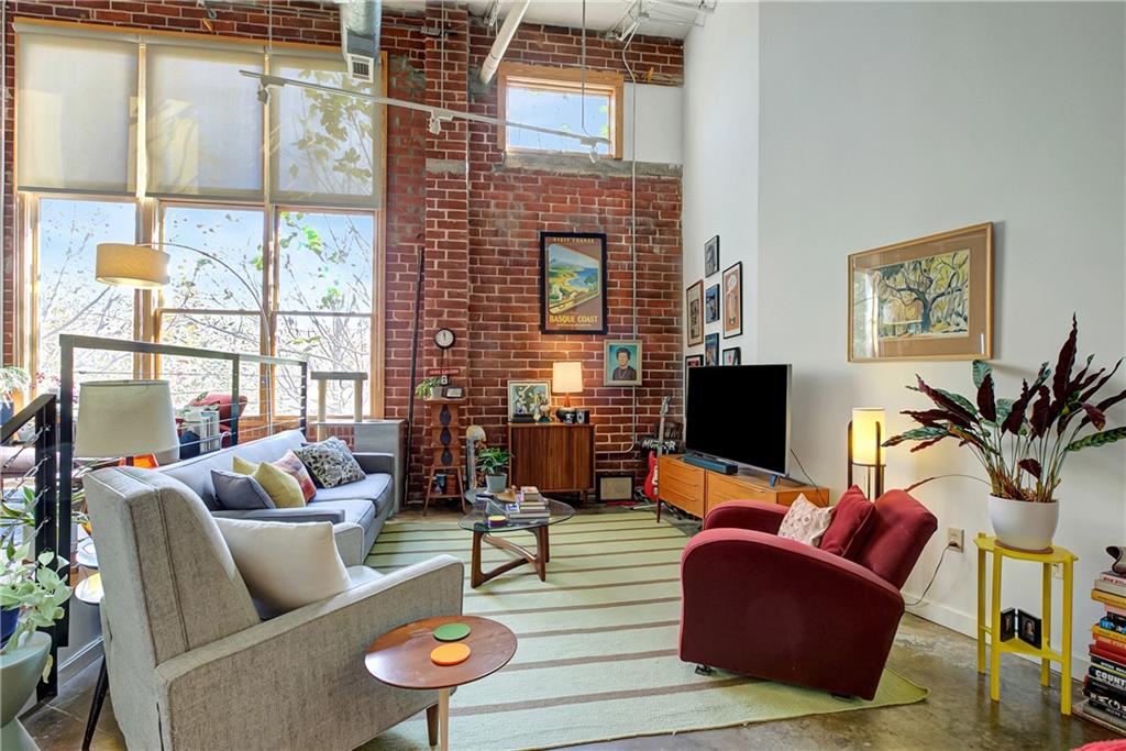 a living room with furniture a flat screen tv and a large window