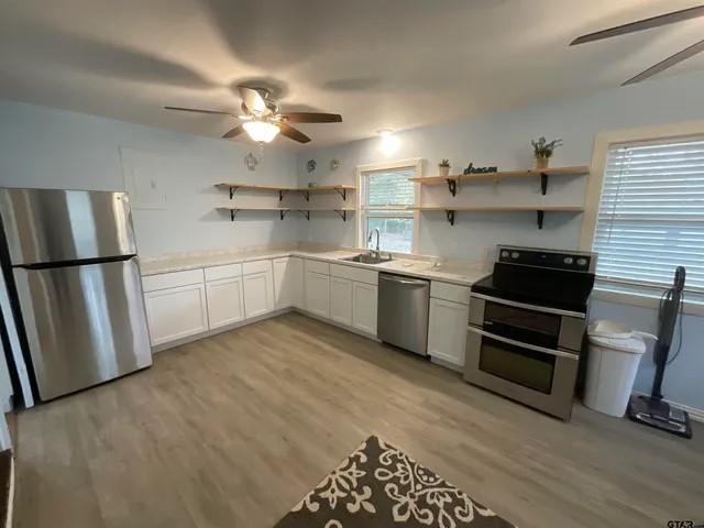 a kitchen with cabinets and wooden floor