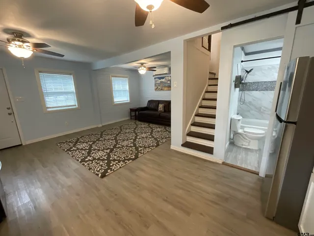 a view of a livingroom with wooden floor and stairs