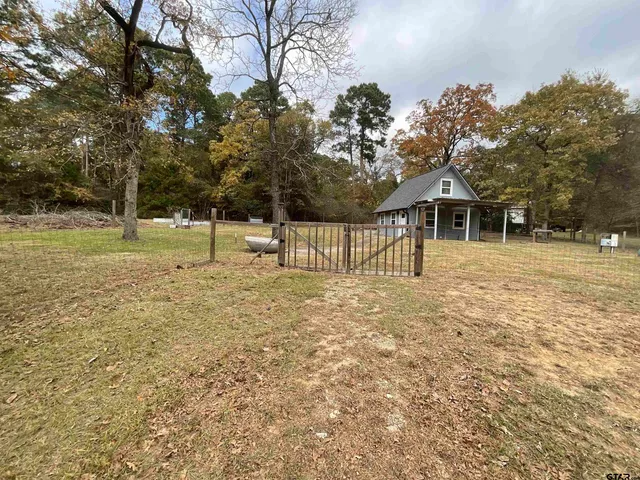 a view of a house with a yard and a tree