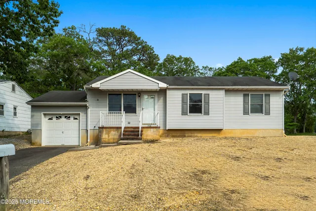 a front view of a house with a garden and yard