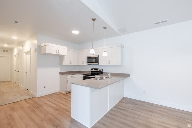 693 West 4500th South, Unit O304 Mapleton, UT 84664 - Photo 12 of 16 Kitchen with stainless steel appliances, light wood-style floors, a peninsula, and white cabinets
