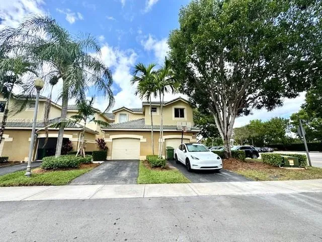 a front view of a house with a yard and trees