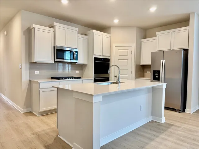 a kitchen with stainless steel appliances a refrigerator stove microwave and sink