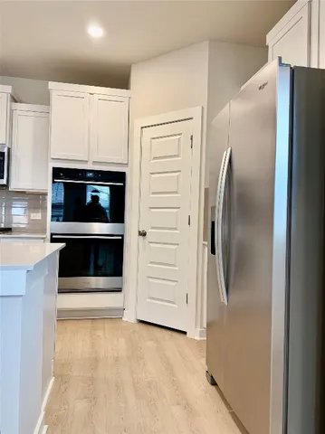 a view of kitchen with stainless steel appliances a refrigerator and a stove top oven