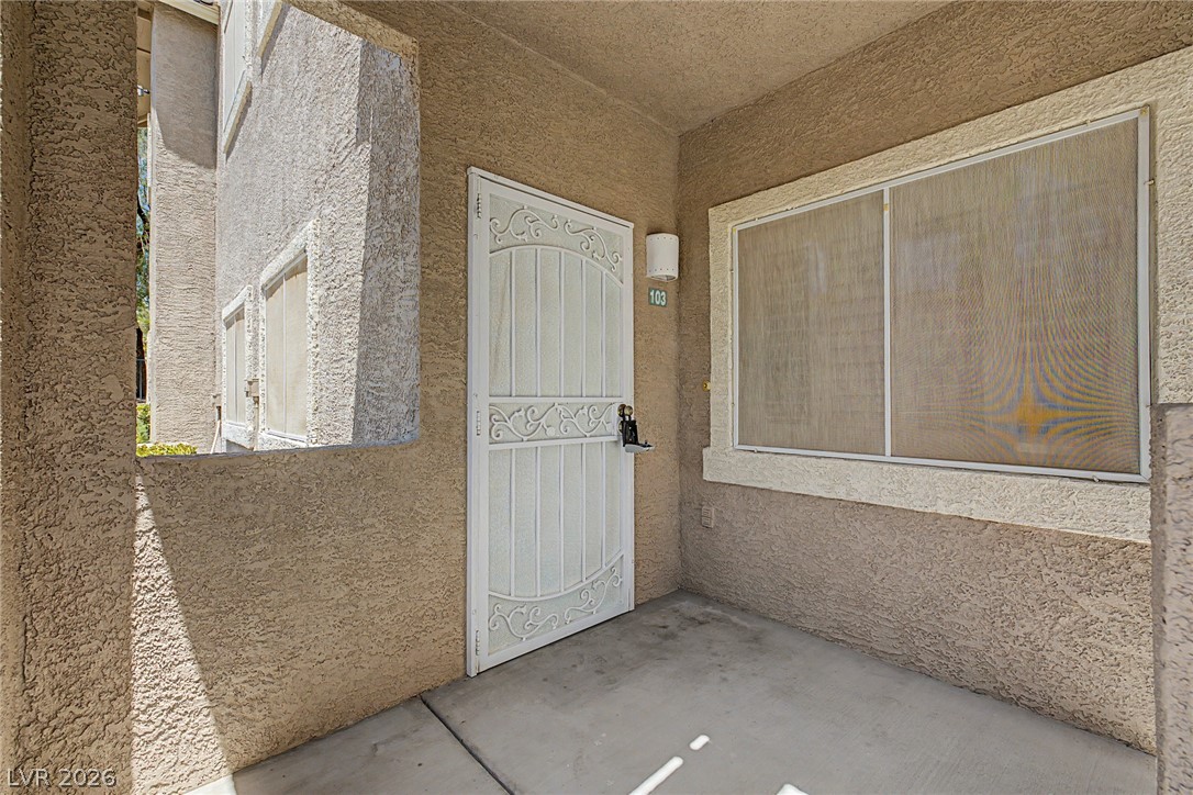 2153 Quarry Ridge Street, Unit 103 Las Vegas, NV 89117 - Photo 10 of 42 Secure entry to a cozy residence, featuring a decorative security screen door and a covered walkway.