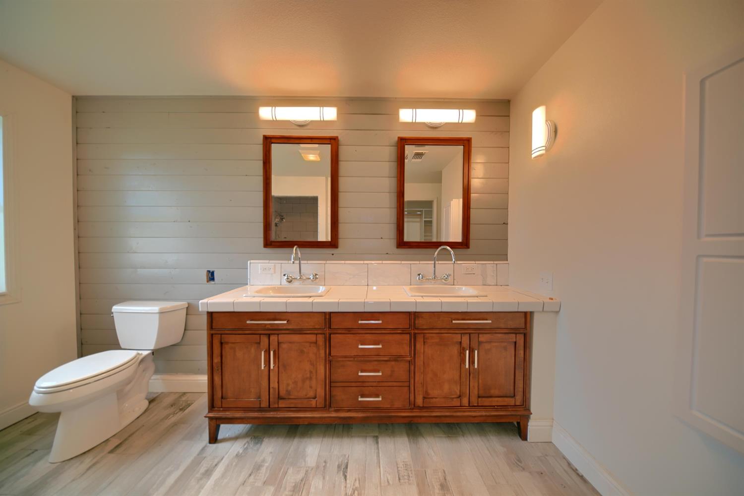 17164 Keyes Road Snelling, CA 95369 - Photo 49 of 97 a bathroom with a toilet a double vanity sink and a mirror