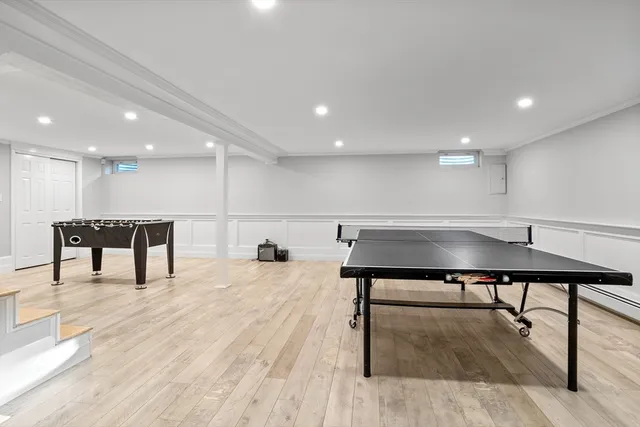 a living room with stainless steel appliances furniture and a wooden floor