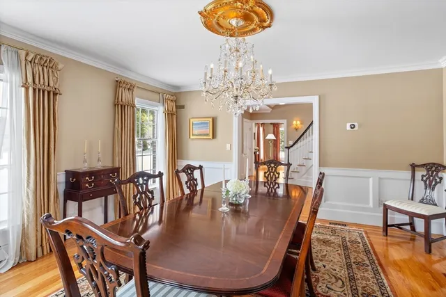 a dining room with furniture a chandelier and wooden floor
