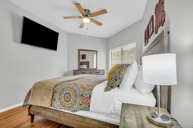 a bedroom with a bed window and a flat screen tv