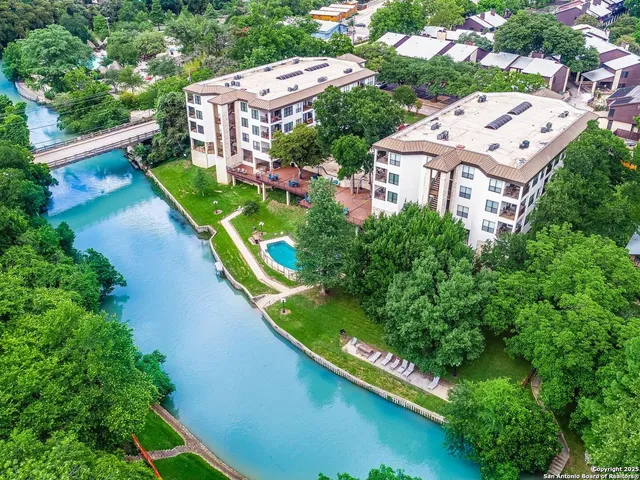 an aerial view of a house with a garden and lake view
