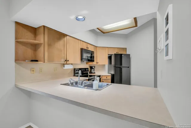 a kitchen with stainless steel appliances a refrigerator sink microwave and cabinets