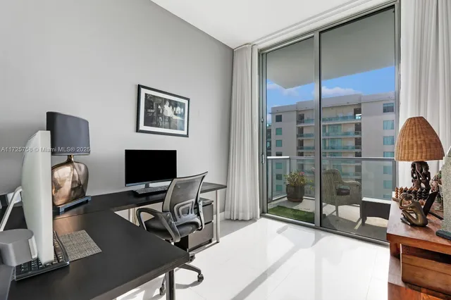 a living room with furniture a rug and a floor to ceiling window