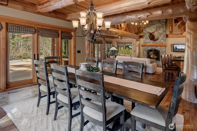 a dining area with furniture a chandelier and wooden floor