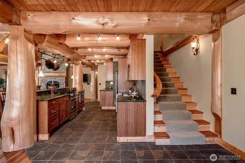 a large white kitchen with granite countertop lots of white cabinets and stainless steel appliances