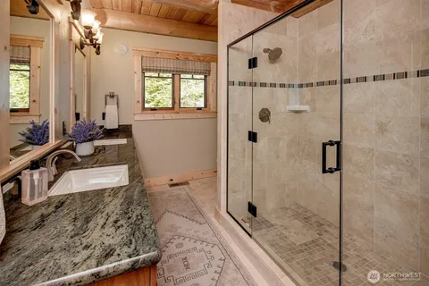 a bathroom with a granite countertop sink a toilet and shower