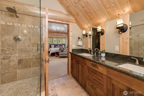 a bathroom with a granite countertop sink a mirror and shower