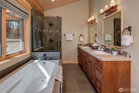 a bathroom with double vanity and a bathtub