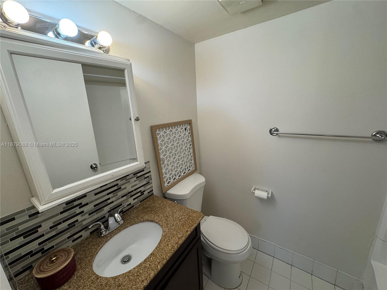 6900 Southwest 39th Street, Unit 206J Davie, FL 33314 - Photo 19 of 28 a bathroom with a granite countertop toilet sink and mirror