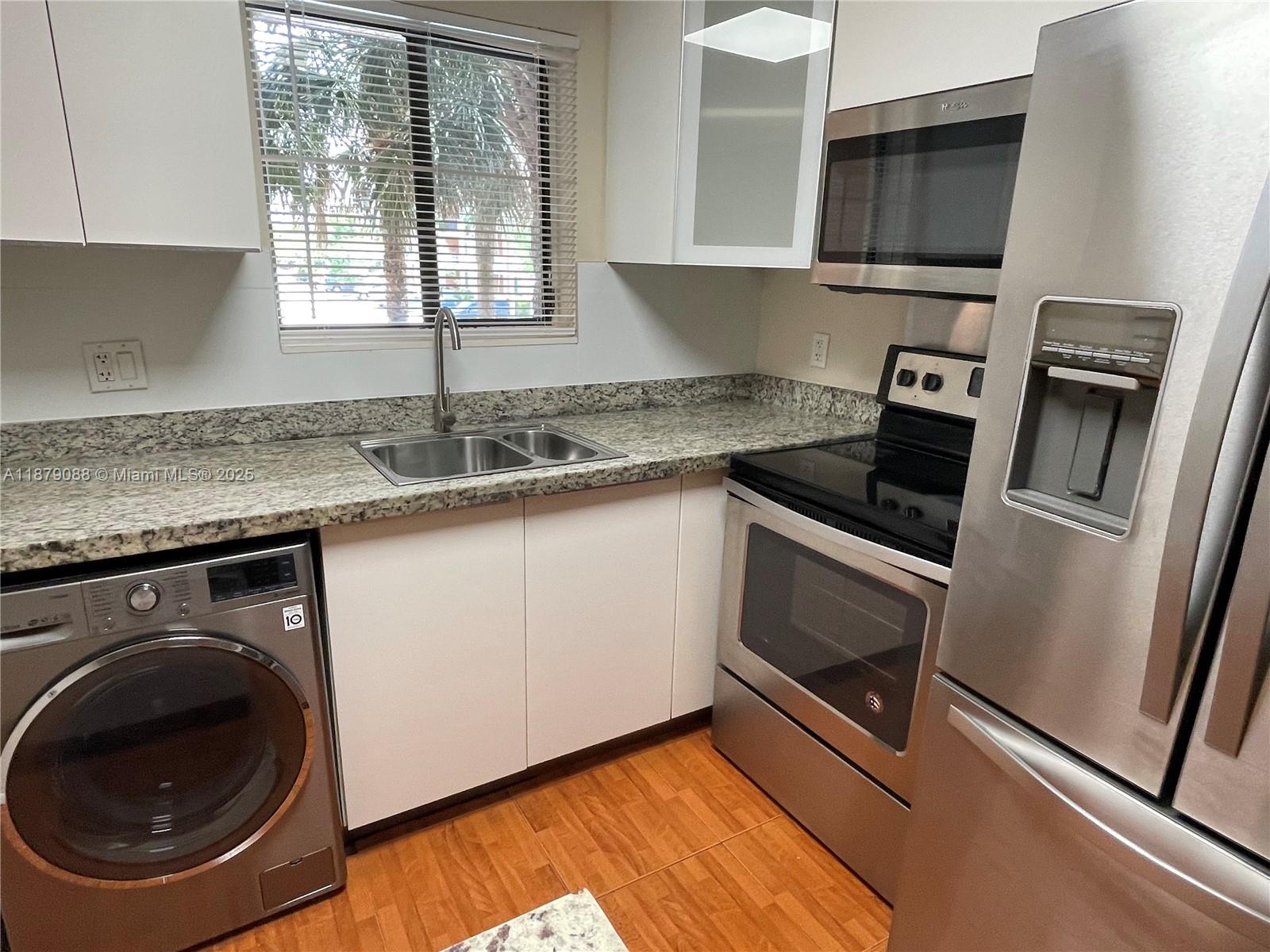 6900 Southwest 39th Street, Unit 206J Davie, FL 33314 - Photo 6 of 28 a kitchen with granite countertop stainless steel appliances a sink stove top oven and cabinets
