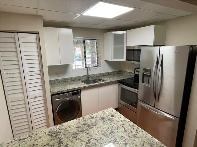 a bathroom with a granite countertop toilet and sink