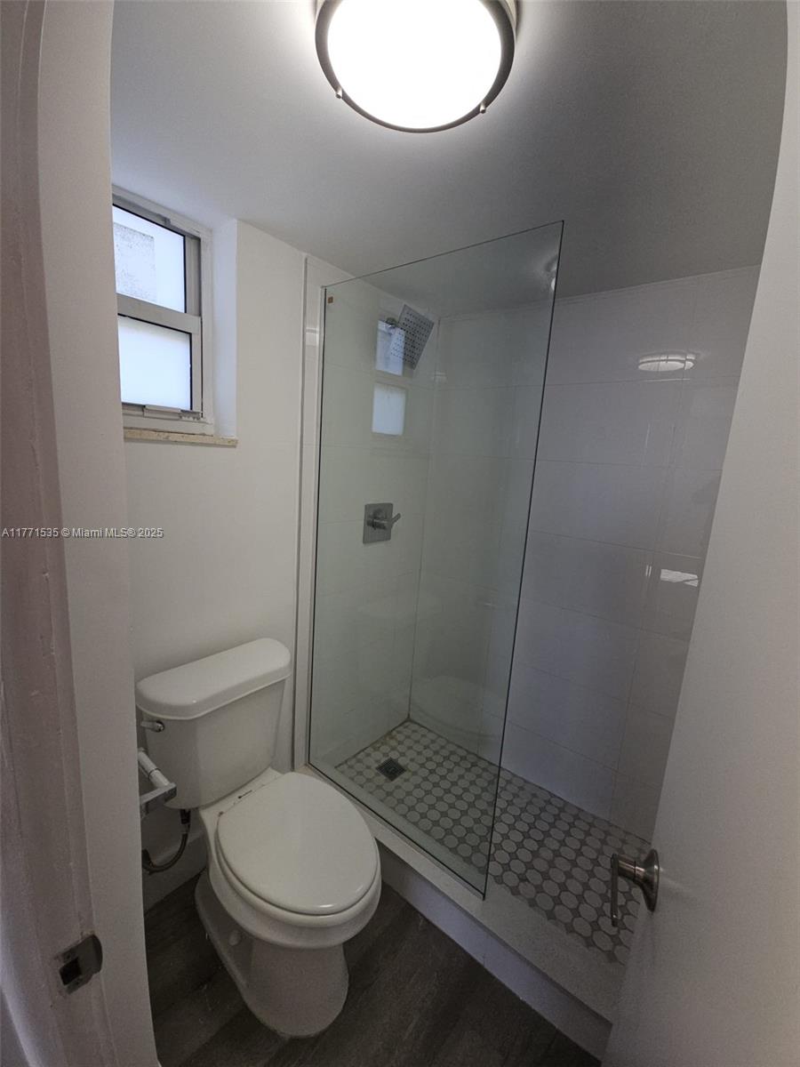 8101 Crespi Boulevard, Unit 304 Miami Beach, FL 33141 - Photo 11 of 25 a bathroom with a toilet and a shower