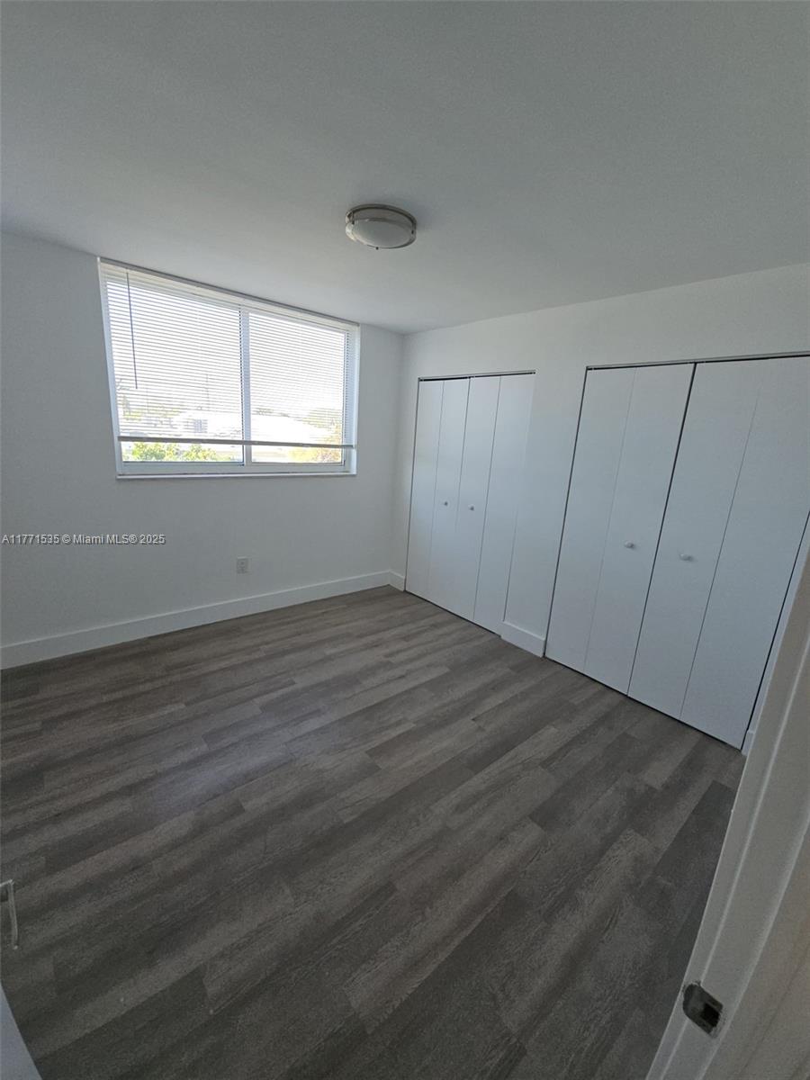 8101 Crespi Boulevard, Unit 304 Miami Beach, FL 33141 - Photo 13 of 25 wooden floor in an empty room with a window
