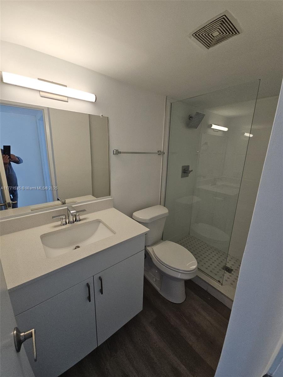 8101 Crespi Boulevard, Unit 304 Miami Beach, FL 33141 - Photo 14 of 25 a bathroom with a sink a toilet a mirror and shower