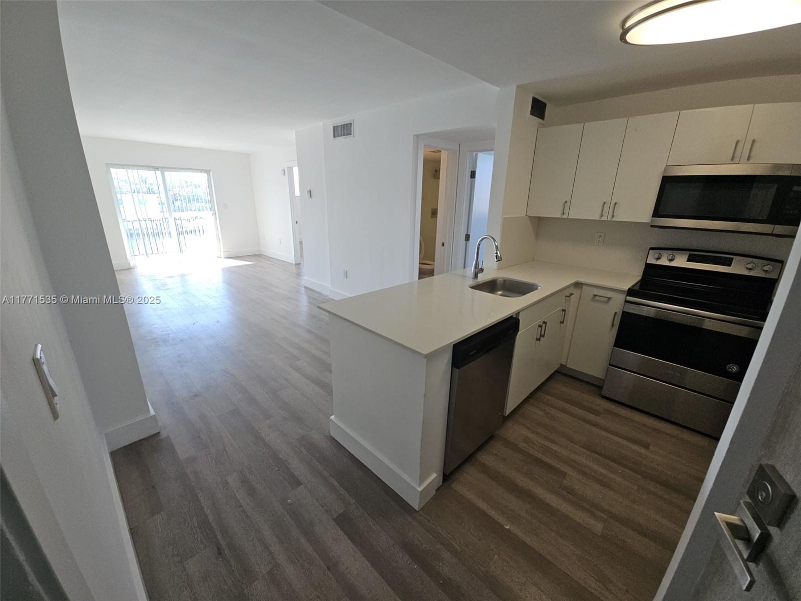 8101 Crespi Boulevard, Unit 304 Miami Beach, FL 33141 - Photo 2 of 25 a kitchen with a sink stove and cabinets