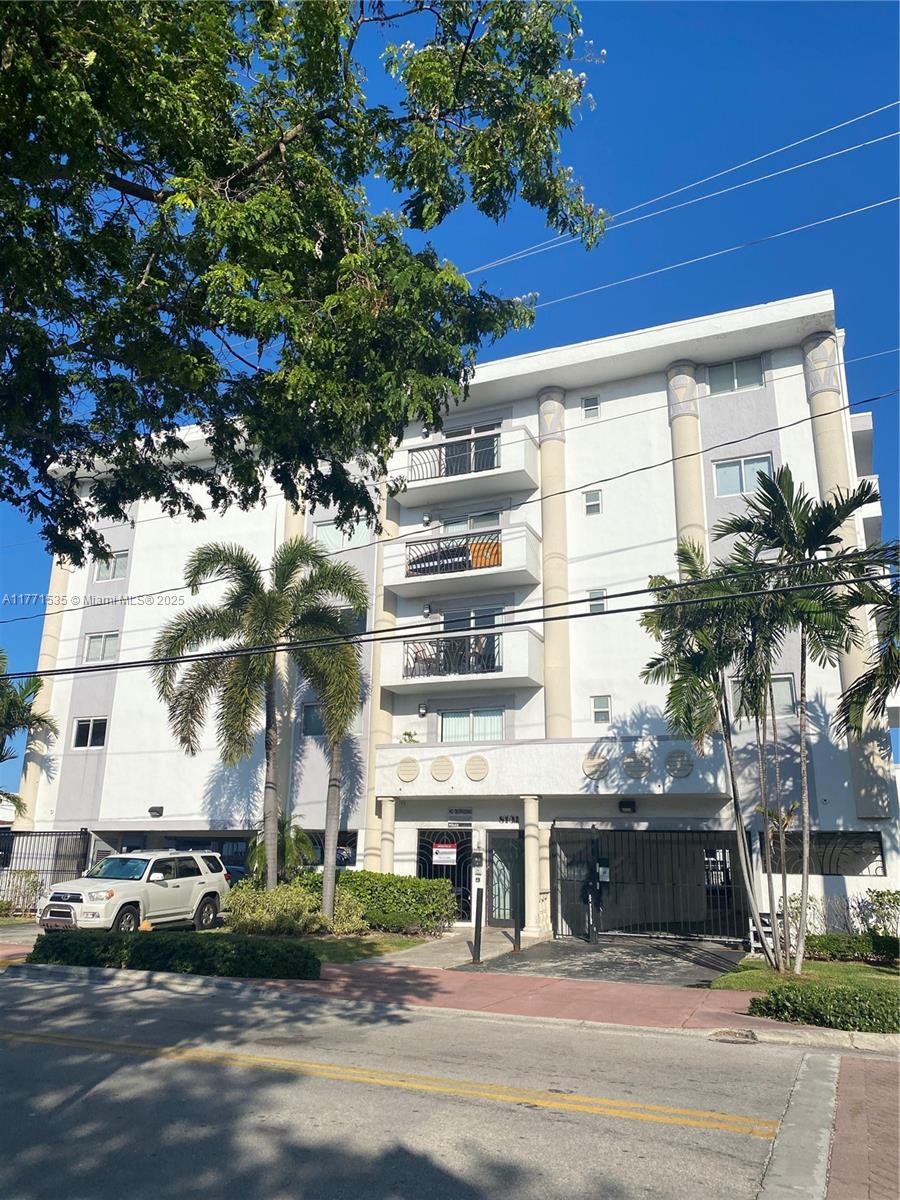 8101 Crespi Boulevard, Unit 304 Miami Beach, FL 33141 - Photo 25 of 25 a front view of residential houses with street and trees