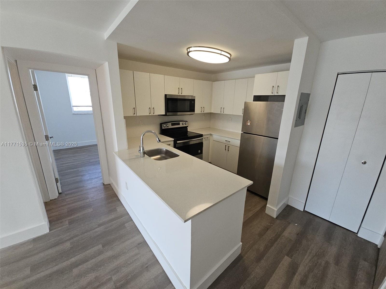 8101 Crespi Boulevard, Unit 304 Miami Beach, FL 33141 - Photo 3 of 25 a kitchen with a refrigerator a sink and a stove