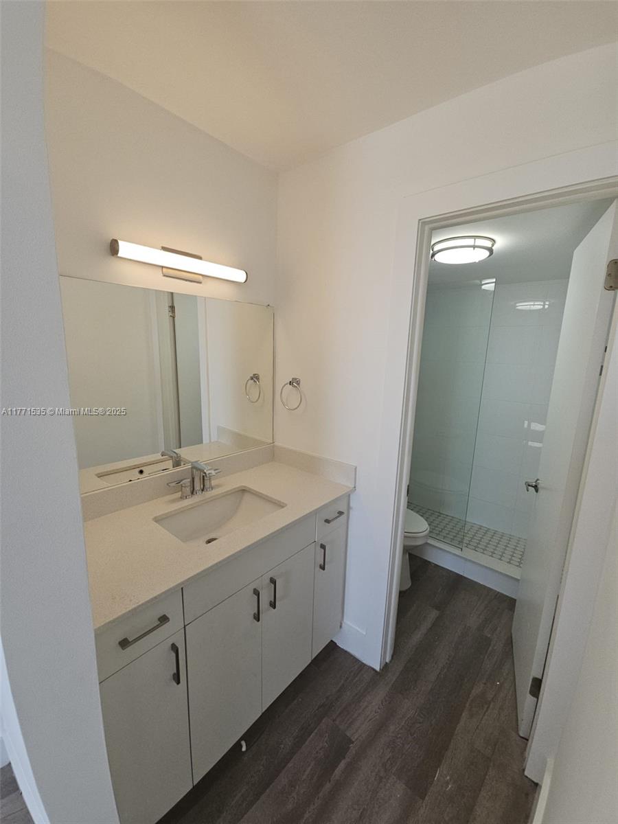 8101 Crespi Boulevard, Unit 304 Miami Beach, FL 33141 - Photo 10 of 25 a spacious bathroom with a double vanity sink and mirror
