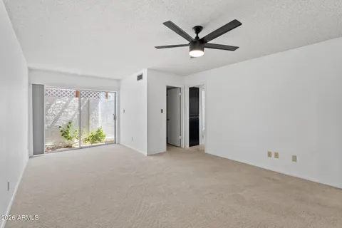a view of a livingroom with a ceiling fan and window