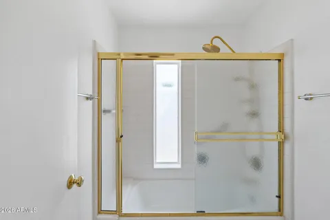 a bathroom with a window and a shower