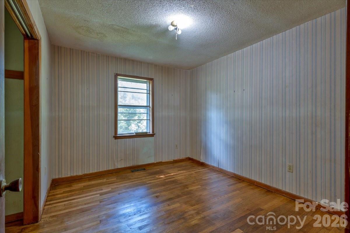 156 Old Sweetwater Road Robbinsville, NC 28771 - Photo 15 of 25 an empty room with wooden floor and windows