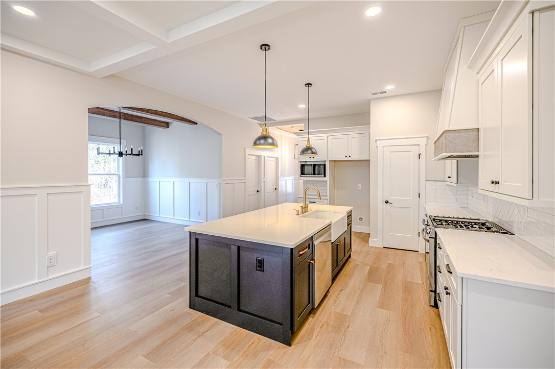 1409 Stonehurst Road Anderson, SC 29621 - Photo 18 of 36 This bright kitchen features a large island and ample counter space, seamlessly connecting to the adjacent dining area.