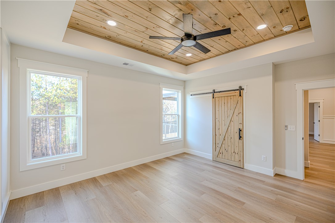 1409 Stonehurst Road Anderson, SC 29621 - Photo 23 of 36 This tranquil room offers natural light, warm wooden floors, and a charming barn door.