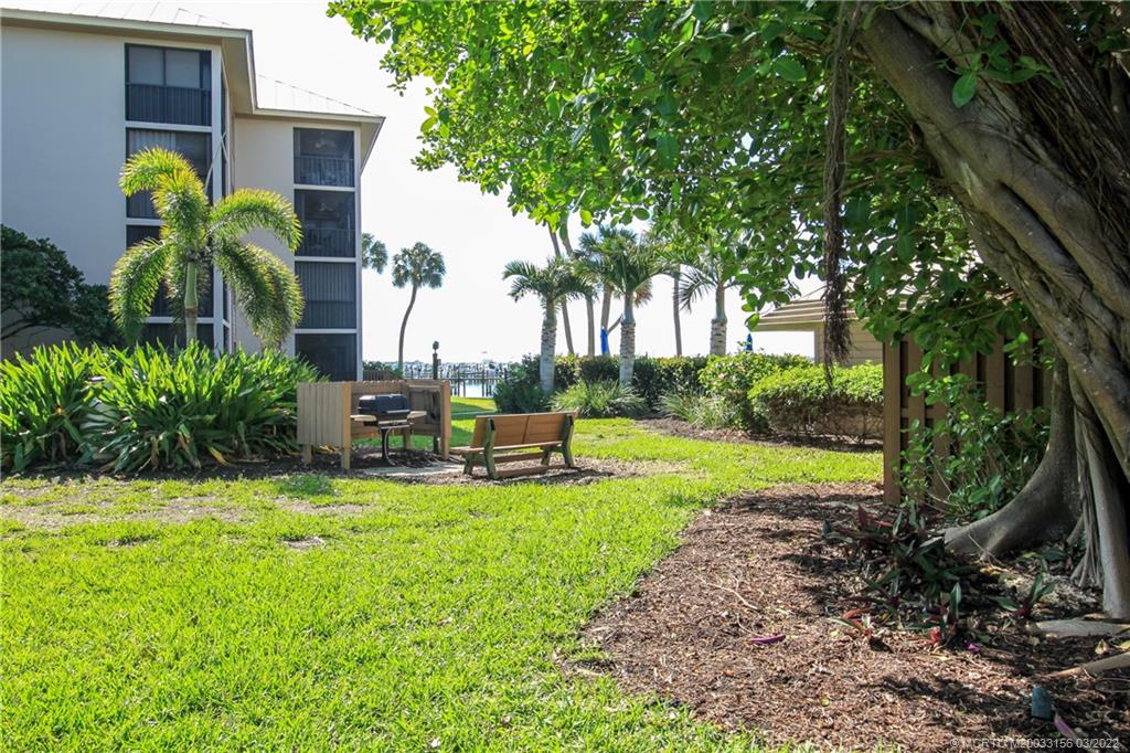 4440 Northeast Sandpebble Trace, Unit 403 Jensen Beach, FL 34957 - Photo 12 of 31 a view of a chair and table in the garden