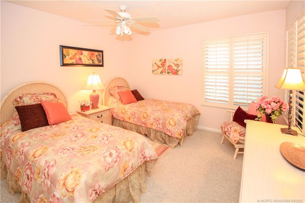 4440 Northeast Sandpebble Trace, Unit 403 Jensen Beach, FL 34957 - Photo 20 of 31 a bedroom with two beds and a window