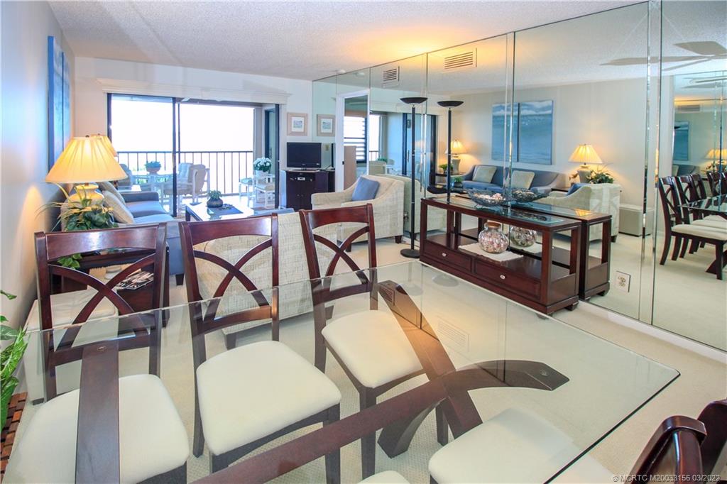 4440 Northeast Sandpebble Trace, Unit 403 Jensen Beach, FL 34957 - Photo 4 of 31 a living room with fireplace furniture and a large window