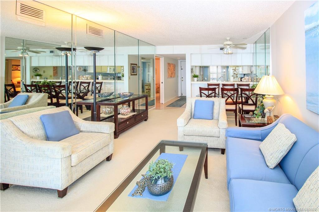 4440 Northeast Sandpebble Trace, Unit 403 Jensen Beach, FL 34957 - Photo 5 of 31 a living room with furniture and a large window