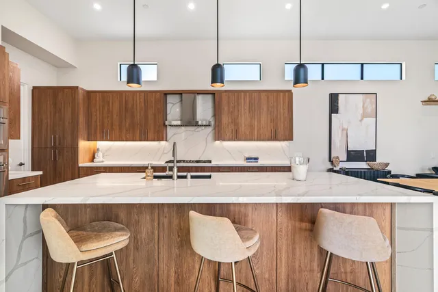 a kitchen with stainless steel appliances granite countertop a kitchen island a table and chairs in it